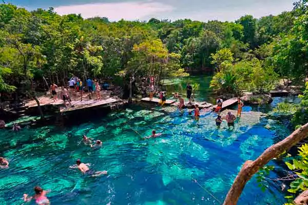 Vista superior del cenote Azul con turistas nadando