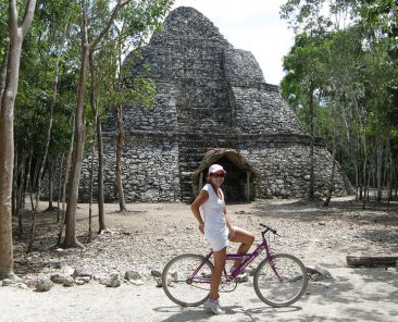 young tourist riding a bicycle in coba