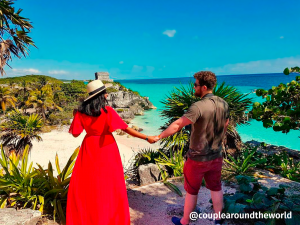 young couple in Tulum pyramid landscape view next to the white sand beach