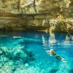 young women swiming in underground cenote