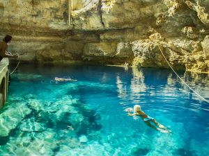young women swiming in underground cenote